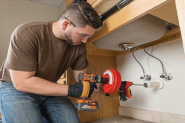 professionele loodgieter die een gootsteen ontstopt