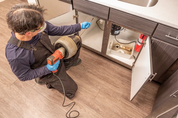 professionele loodgieter die een gootsteen ontstopt