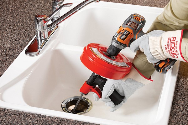 professionele loodgieter die een gootsteen ontstopt