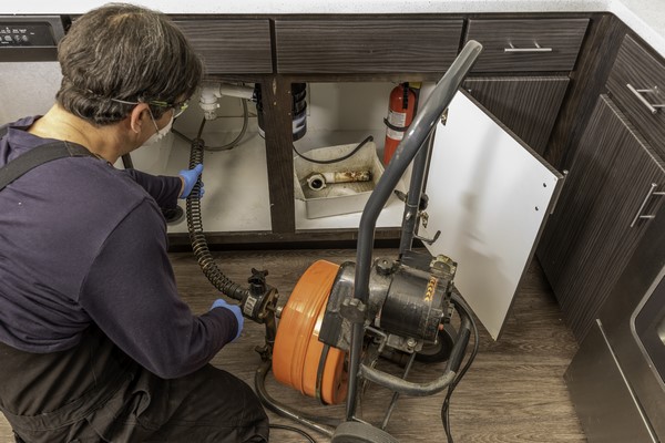 professionele loodgieter die een gootsteen ontstopt