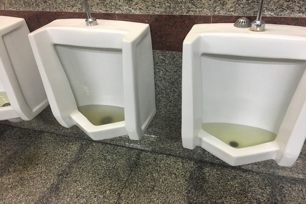 loodgieter die een urinoir ontstopt